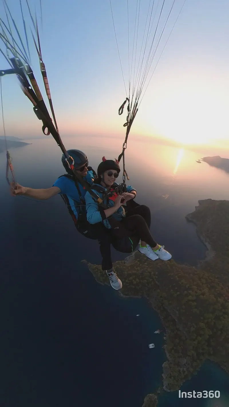 Alçalan güneşin ışığında deniz üzerinde tandem uçuş