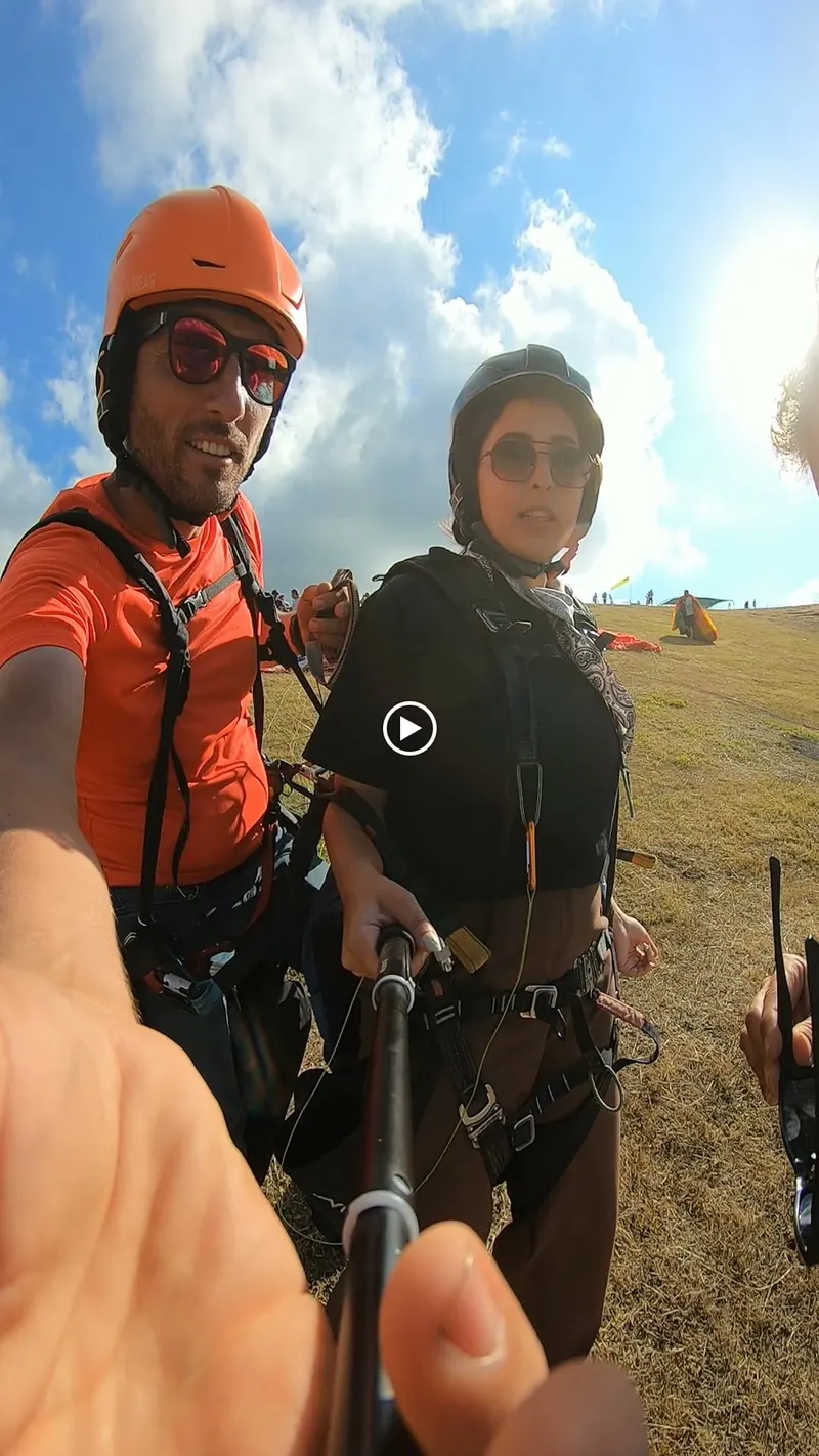 Kask ve kuşamlarıyla uçuş öncesinde yan yana duran pilot ve yolcu
